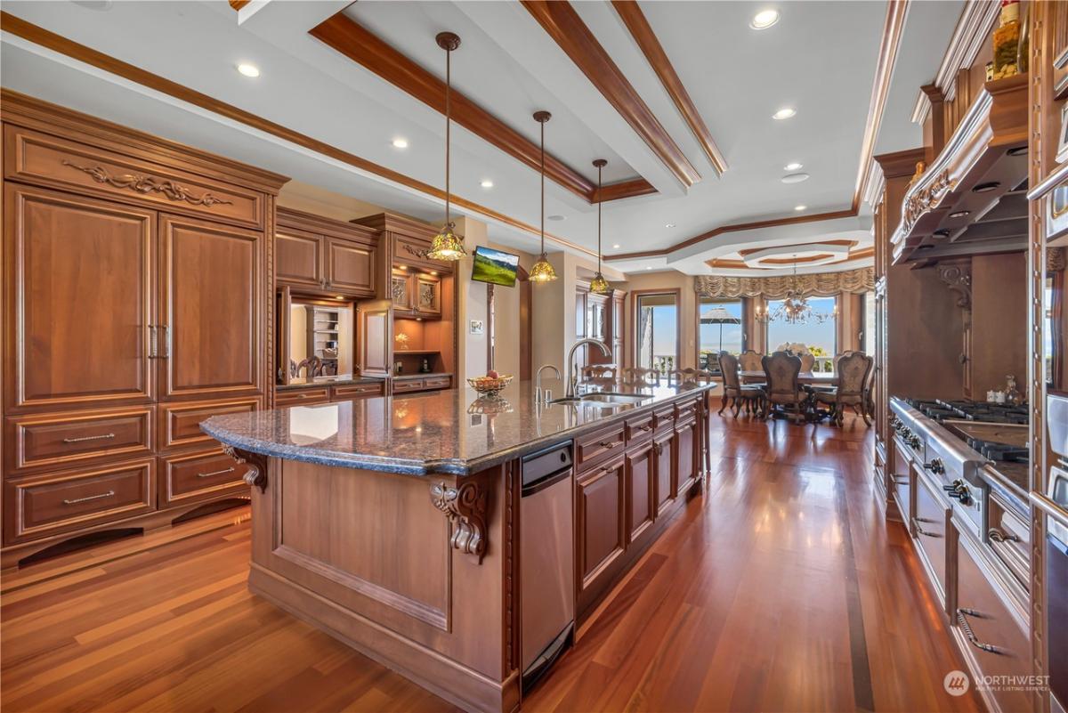 Kitchen with a large island, custom lighting and custom cabinetry.