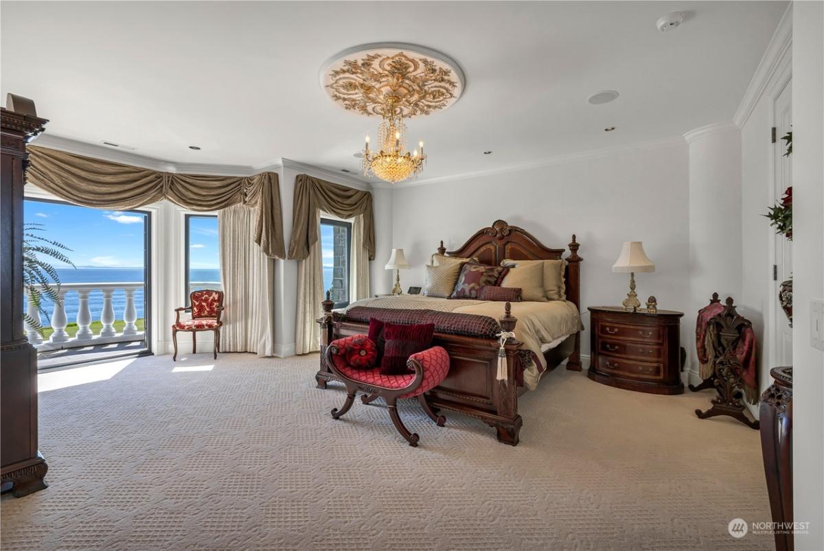 Bedroom with a chandelier, carpet flooring and a balcony.