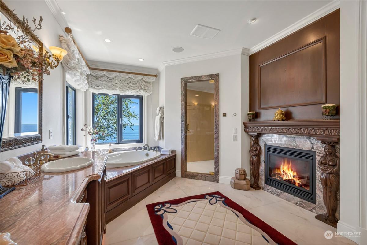 Bathroom with sinks, fireplace and soaking tub.