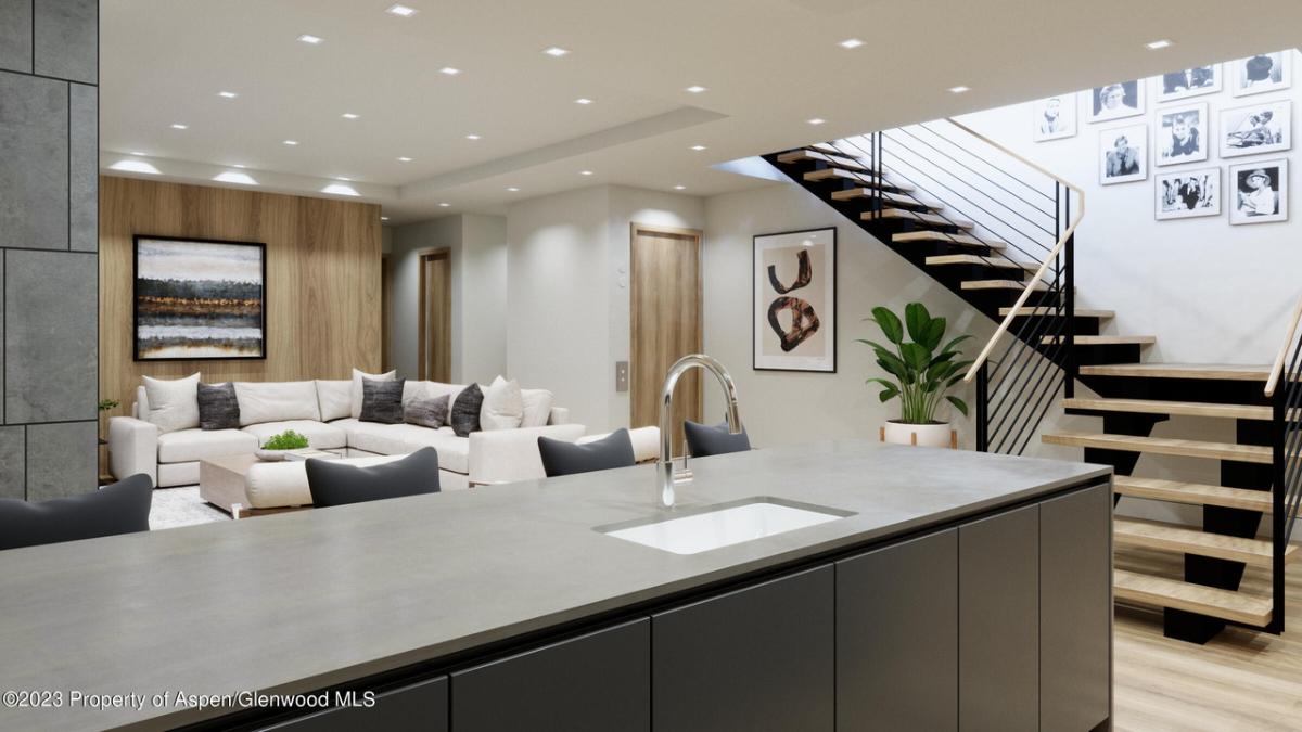 Kitchen adjacent to the living room with staircase leading up to the second floor.