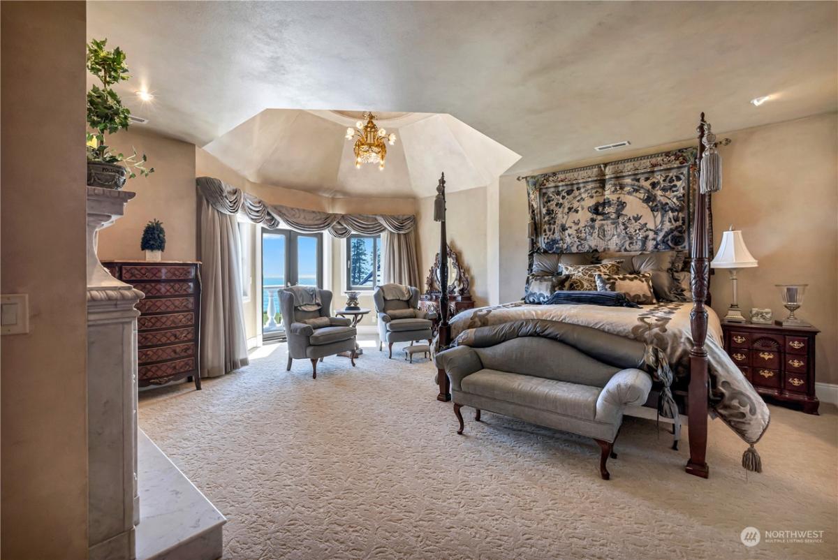 Bedroom with a chandelier, carpet flooring and glass doors.