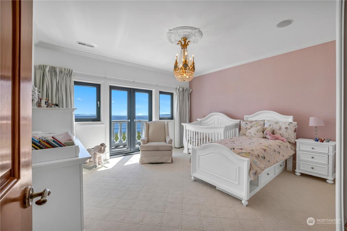 Bedroom with a chandelier, carpet flooring and glass doors.