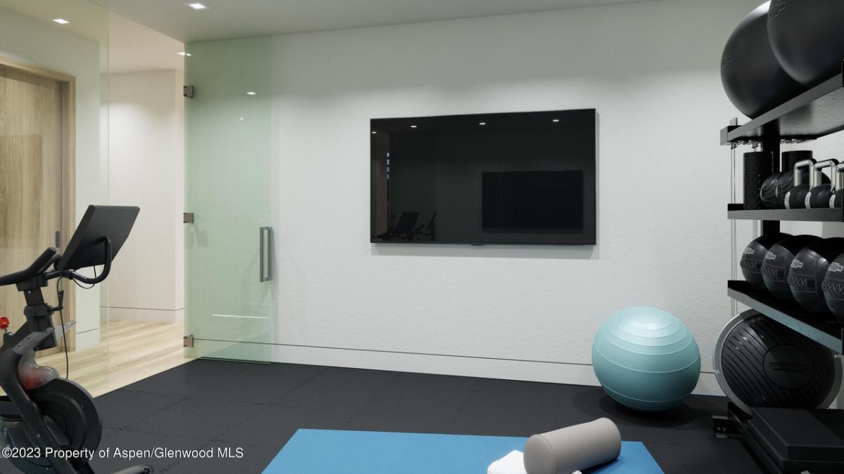 Home gym with workout equipment and a TV.