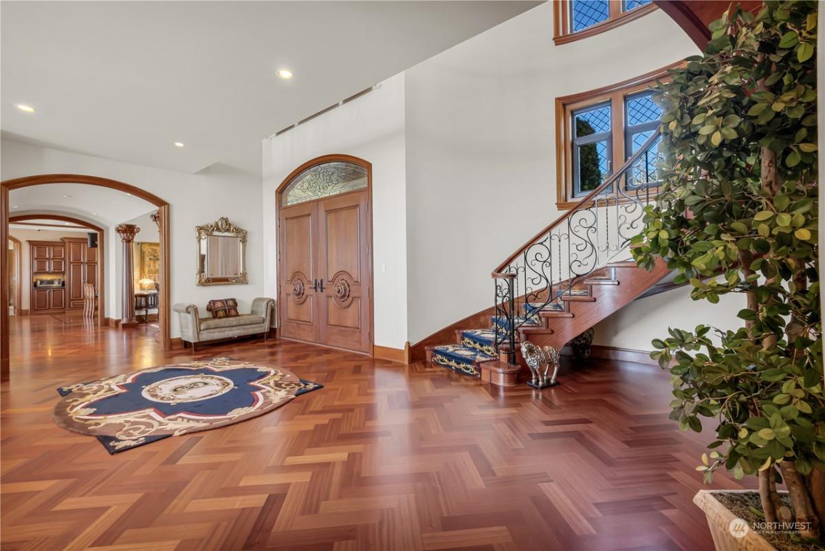 Foyer with wood flooring and staircase.