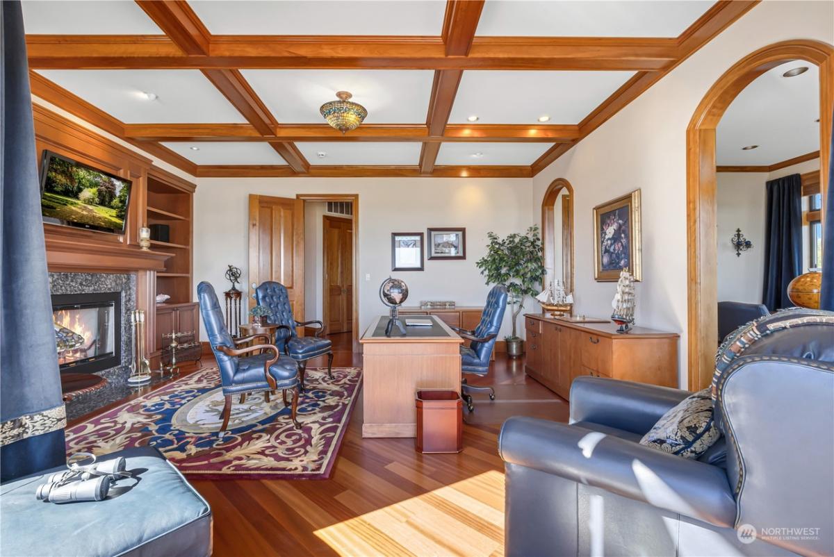 Home office with a fireplace and open beam ceiling.