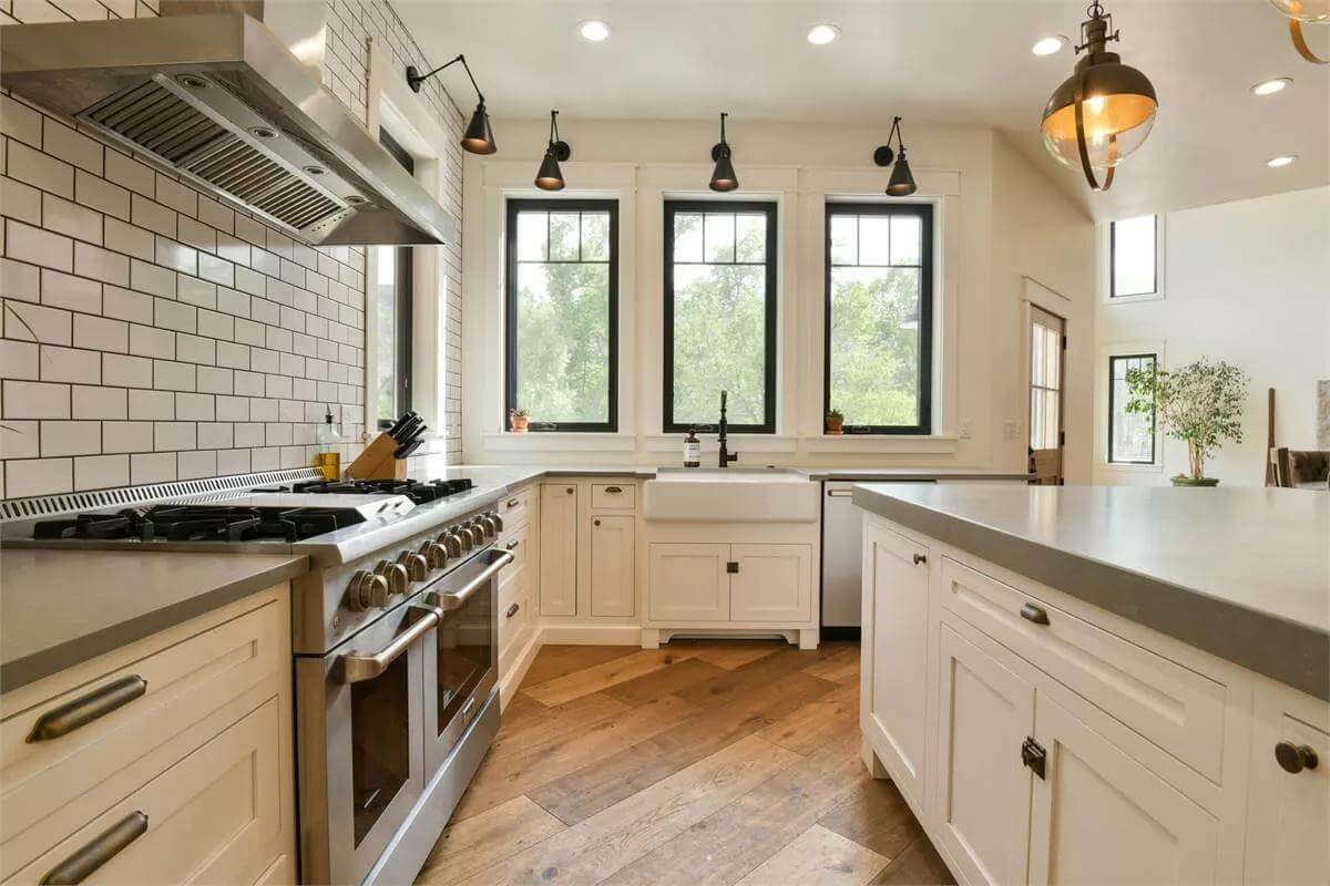 The kitchen includes a farmhouse sink under the triple windows.