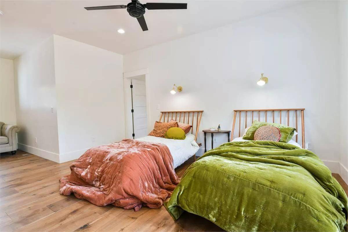 Bedroom with two single beds over the hardwood flooring.