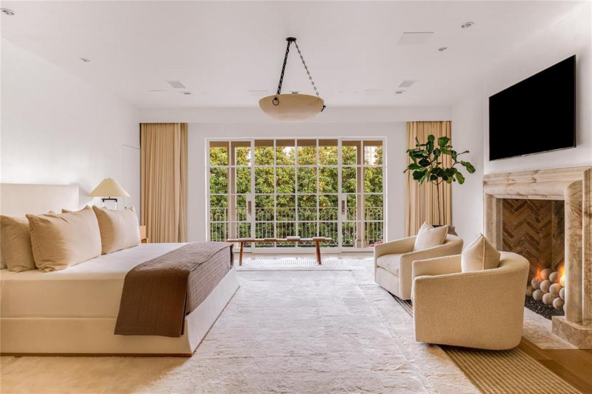 Bedroom with glass doors and a fireplace.