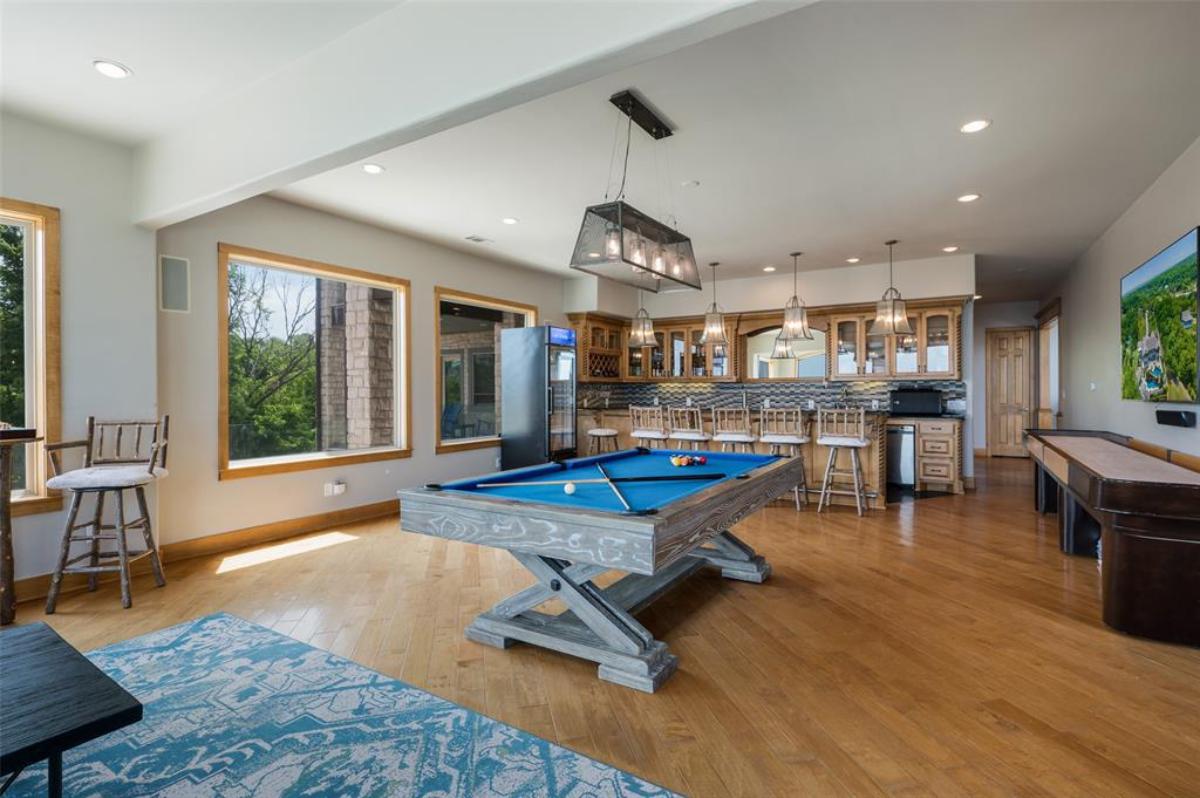 Billiards room with hardwood floor and glass windows.