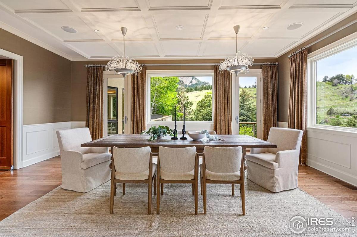 Dining room with a wood table and chandeliers.