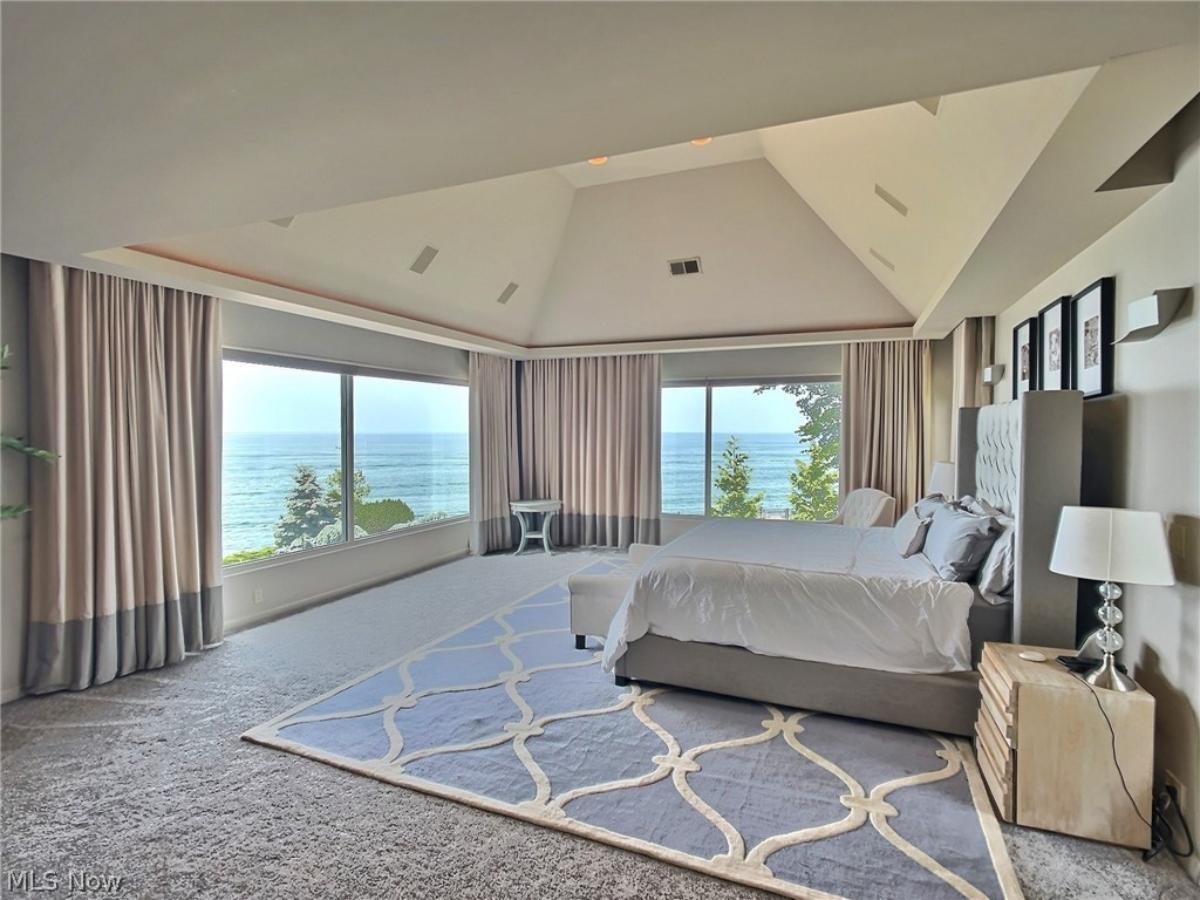 Bedroom with carpet flooring and huge glass windows.