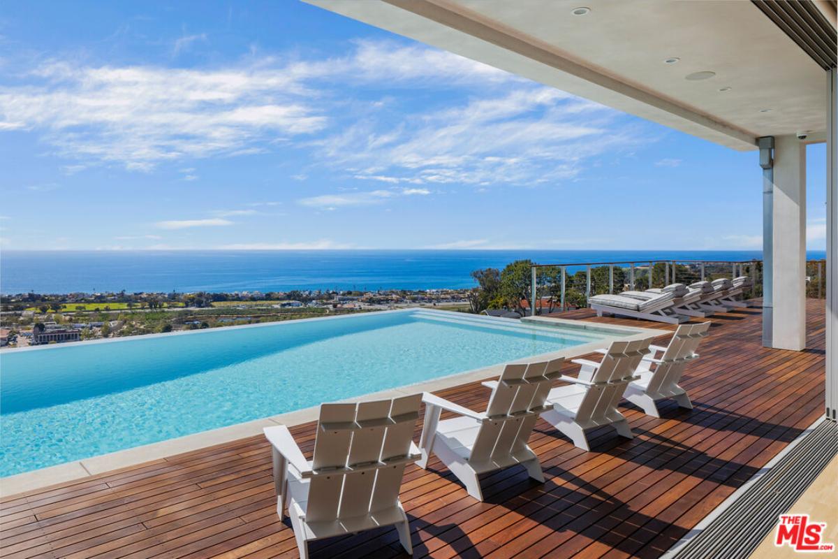 Pool with lounge chairs overlooking the ocean.