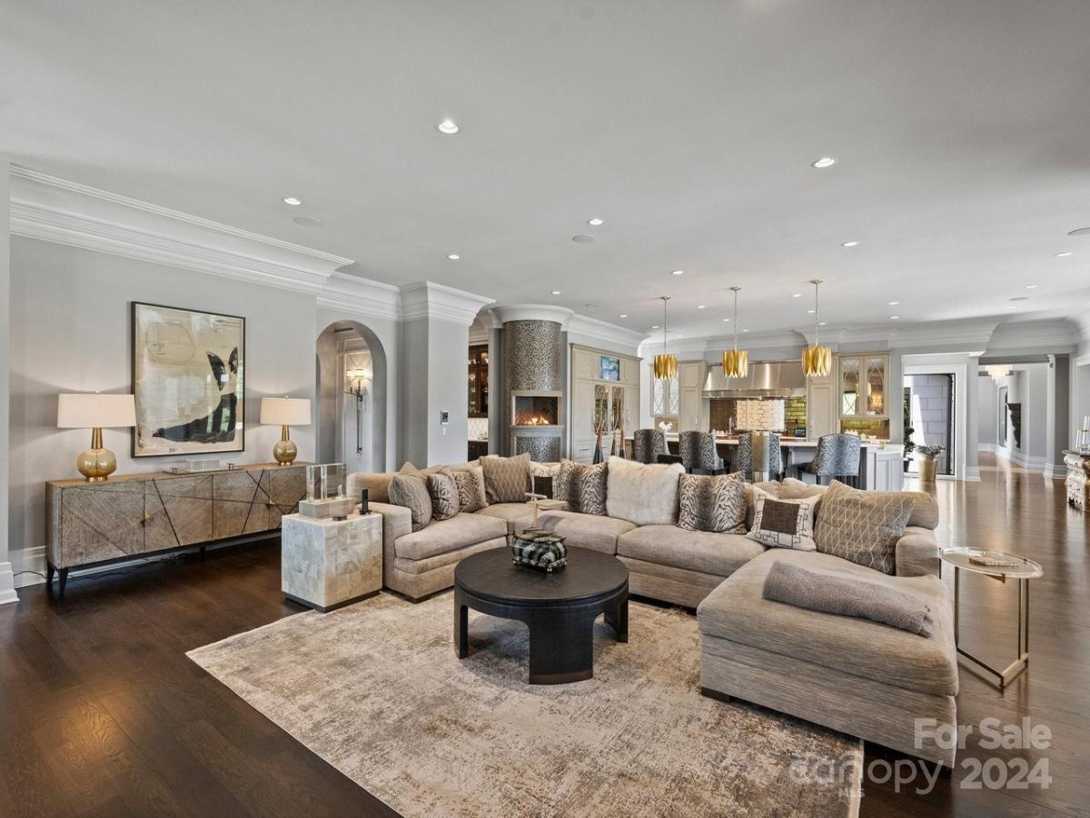 Living room with couches and hardwood flooring.