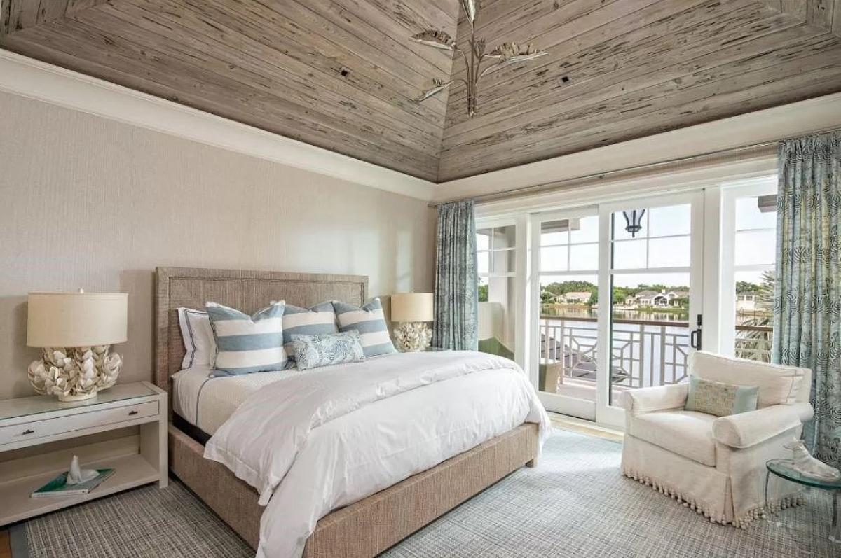 Bedroom with a large bed, carpet flooring and a sliding glass door.