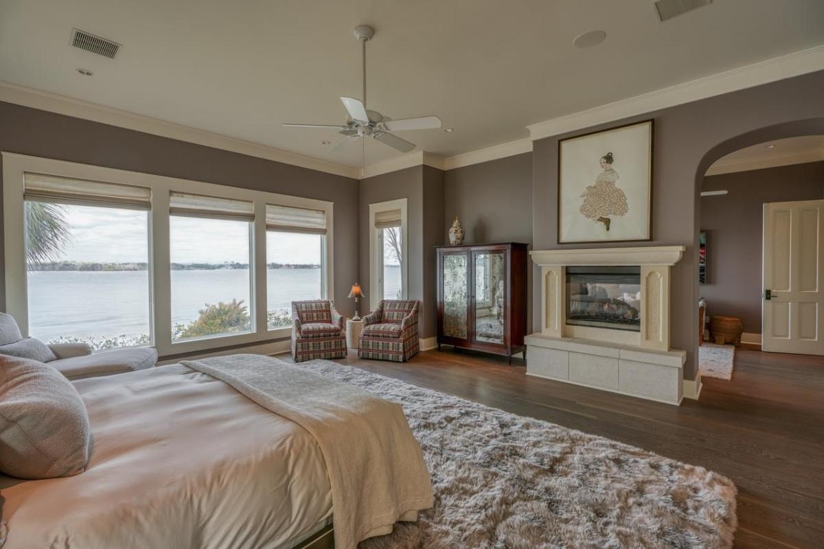 Bedroom with a fireplace and glass windows.