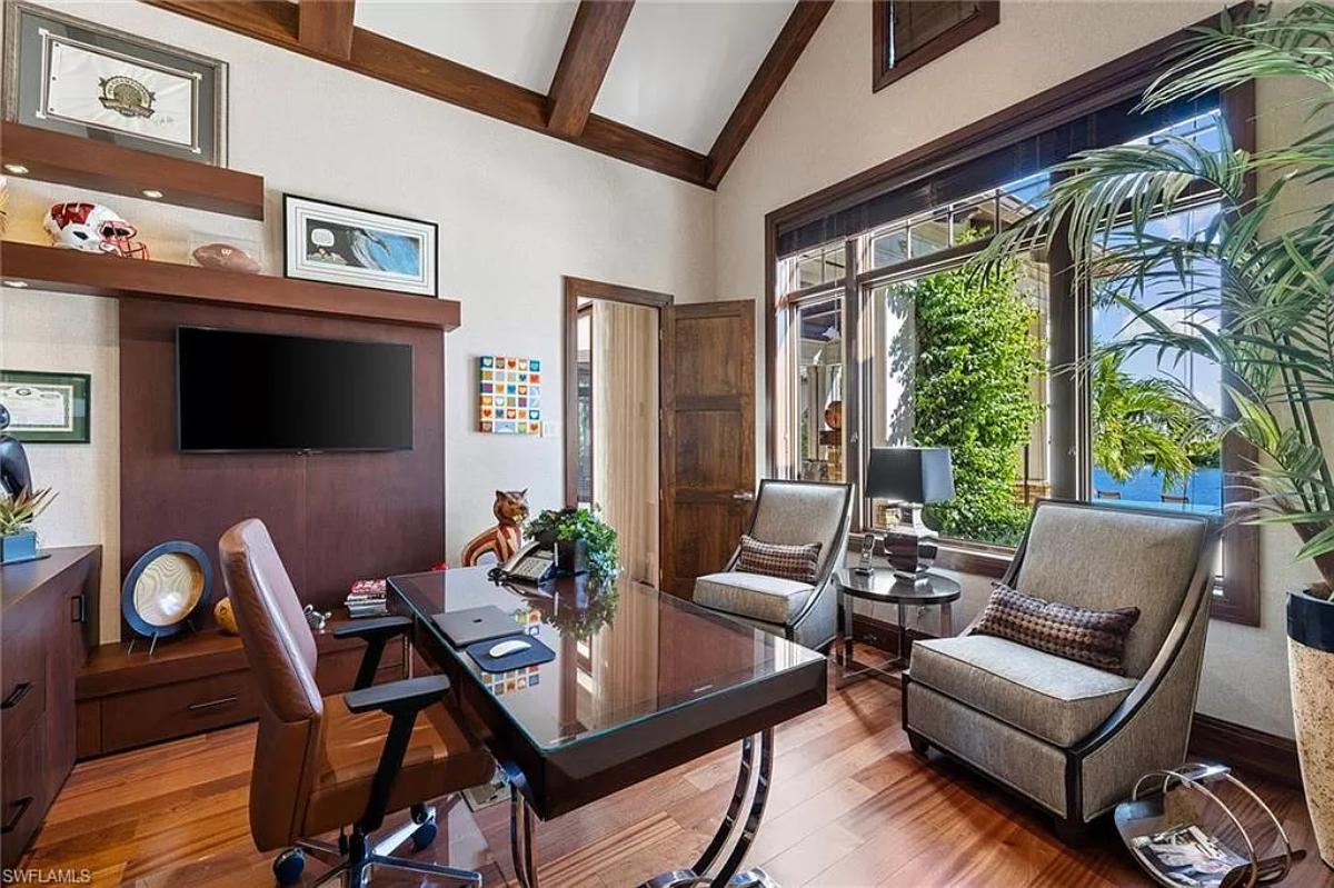 Home office with hardwood floors and glass windows.