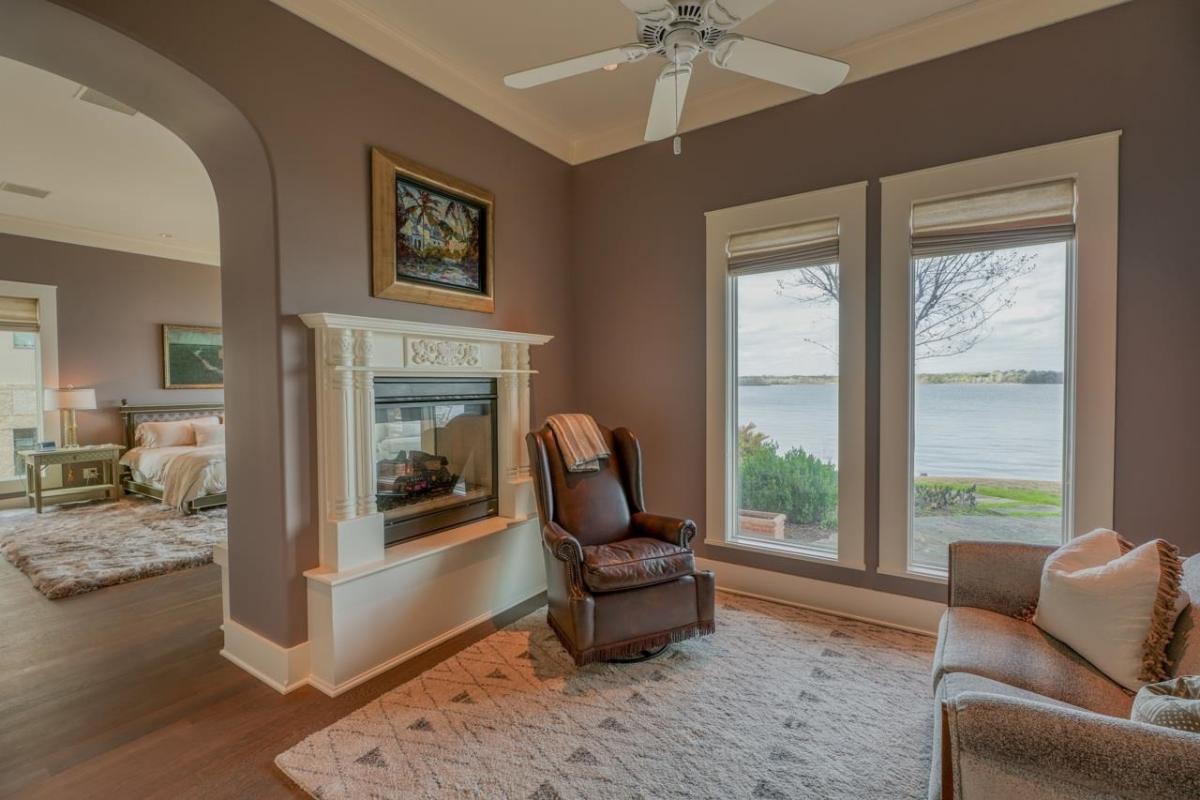 Sitting area with a fireplace and glass windows.