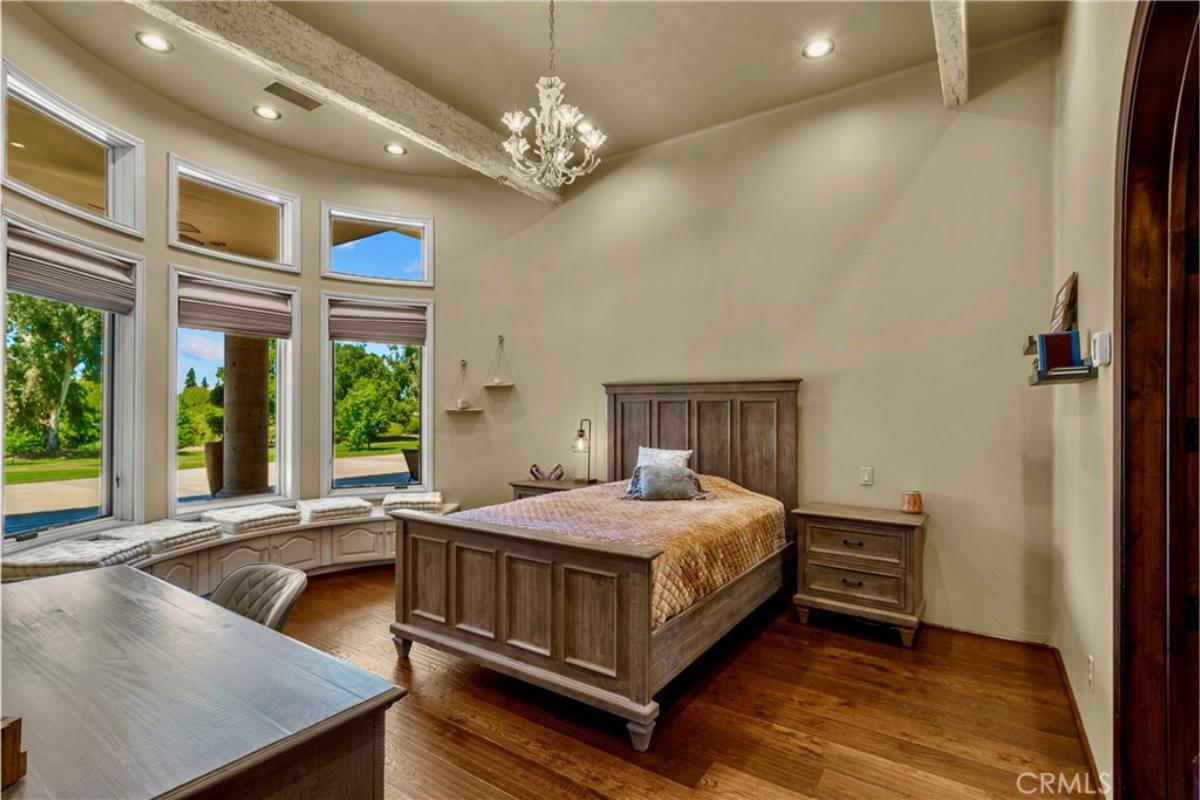 Bedroom with hardwood flooring and glass windows.