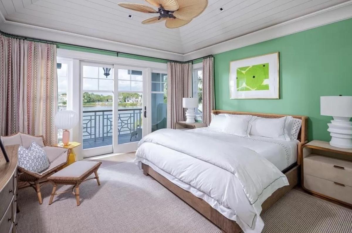 Bedroom with a large bed, carpet flooring and a sliding glass door.