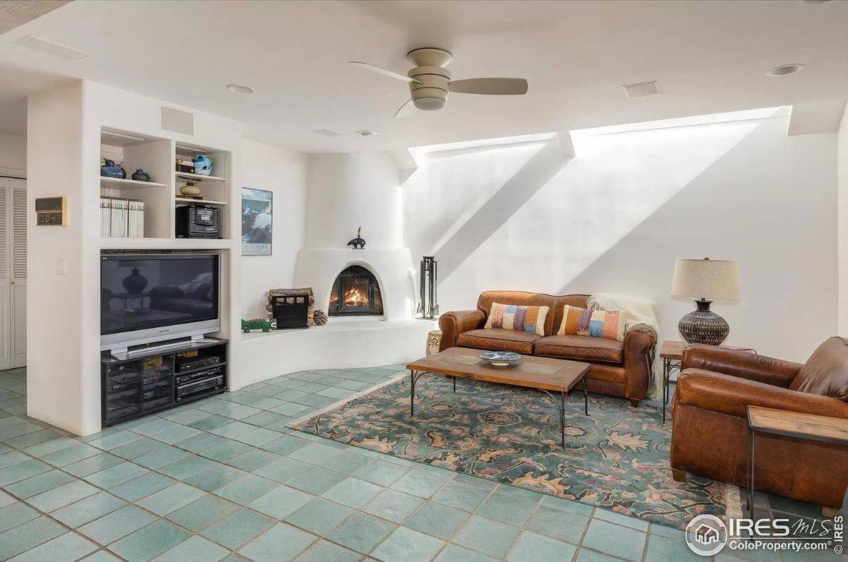 Family room with leather sofas, a TV, and a kiva fireplace.