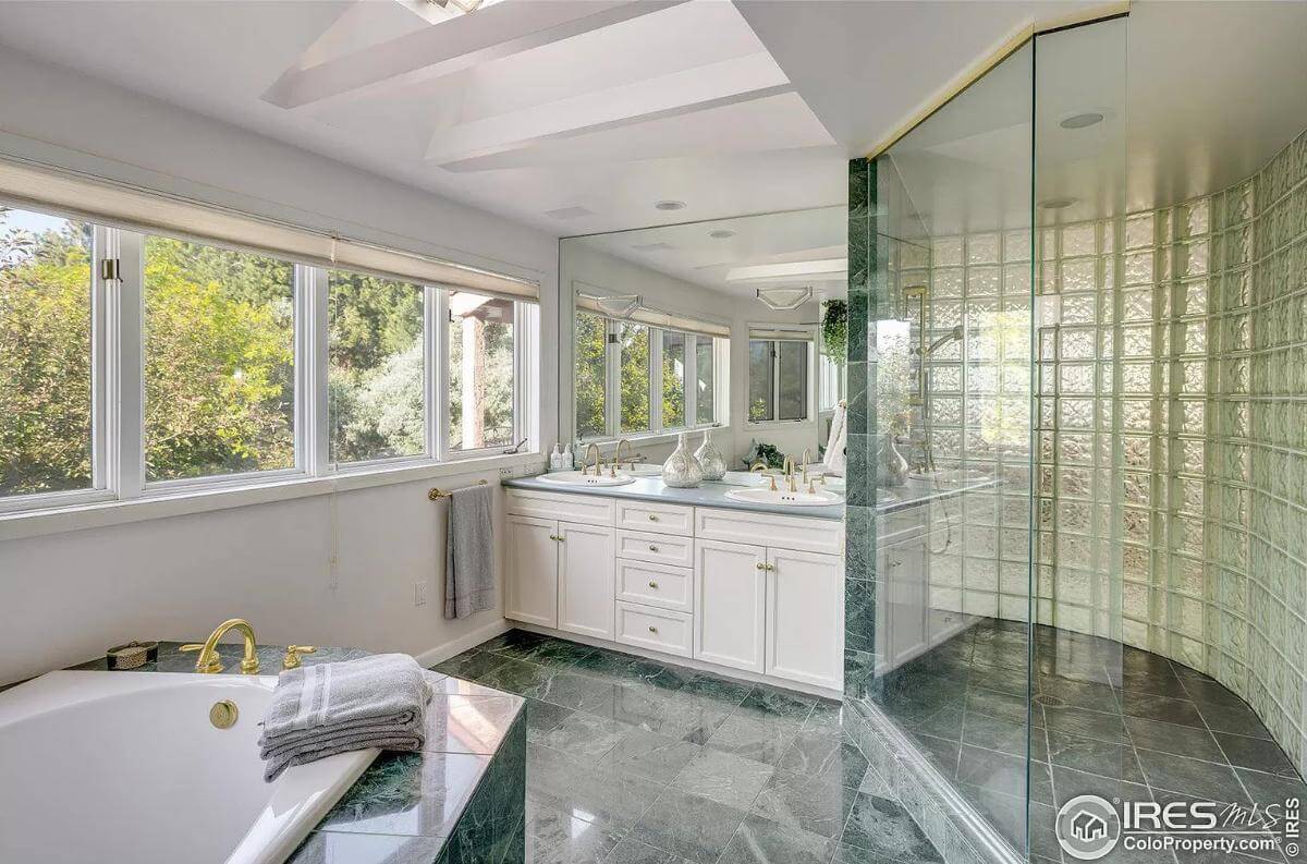 Primary bathroom with a soaking tub, a corner shower, and a dual sink vanity.