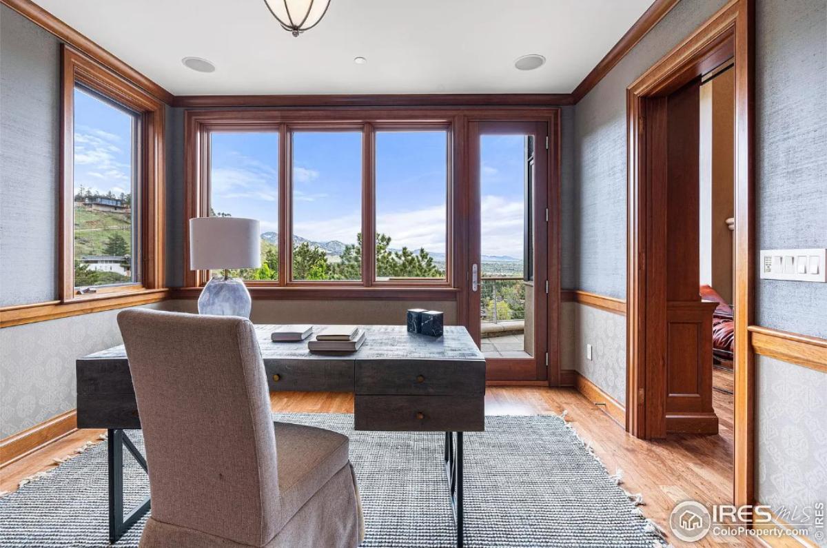 Home office with hardwood floors and glass windows.