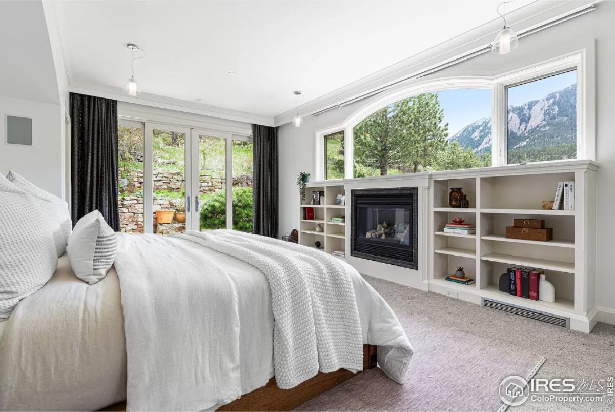 Bedroom with carpet flooring, glass windows and glass doors.