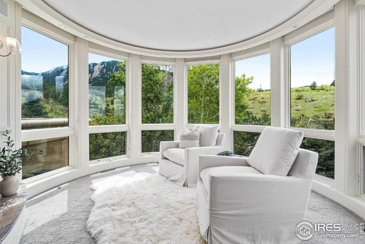 Sunroom with couches and glass walls.