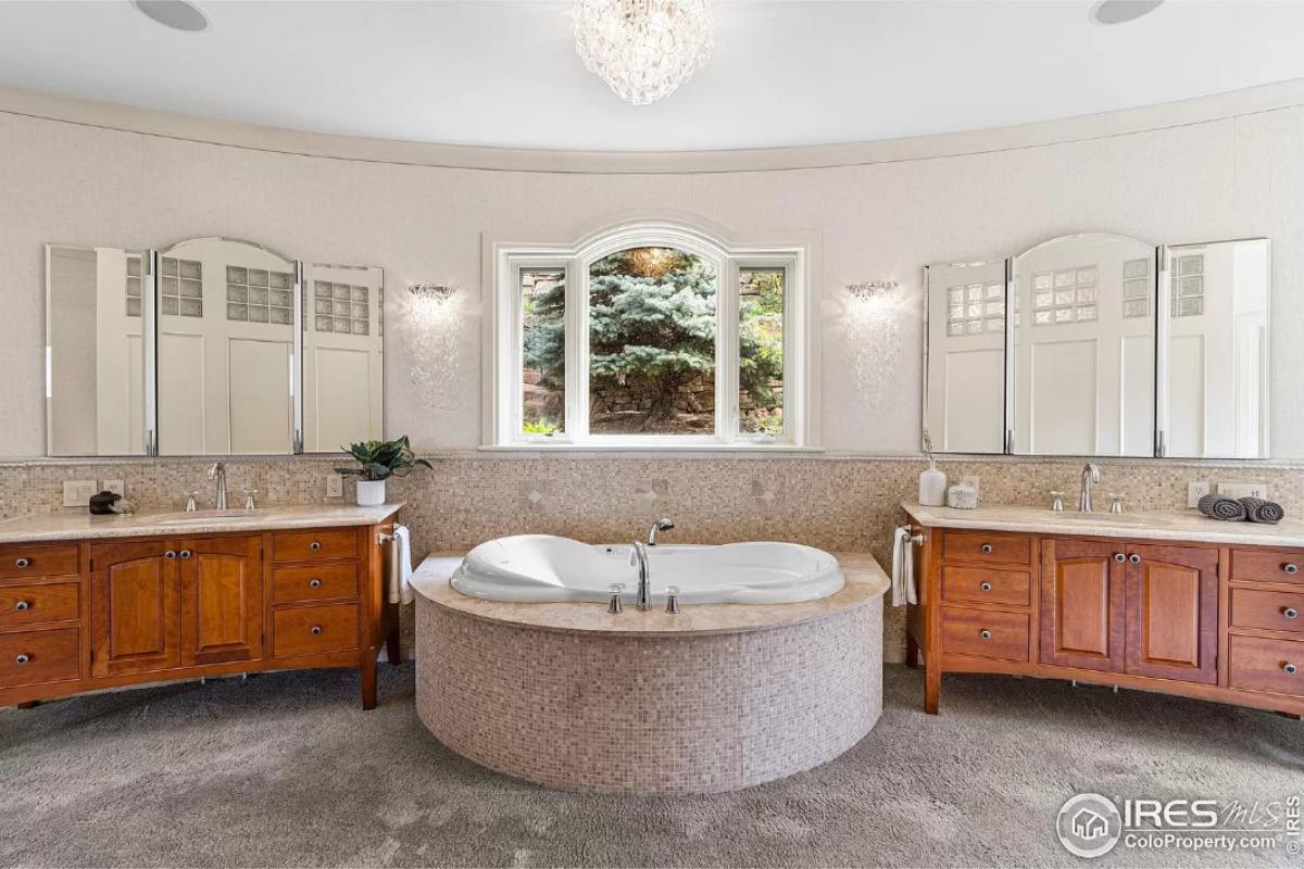 Bathroom with custom-made vanities and a soaking tub.