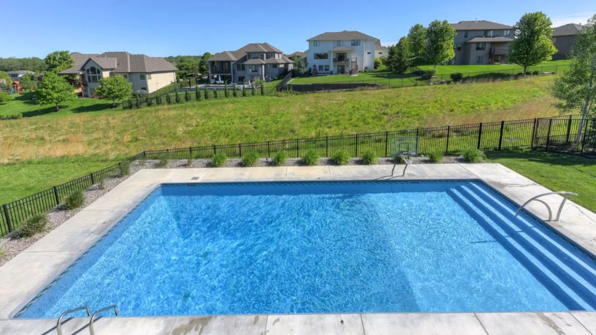 A swimming pool surrounded by a metal fence.