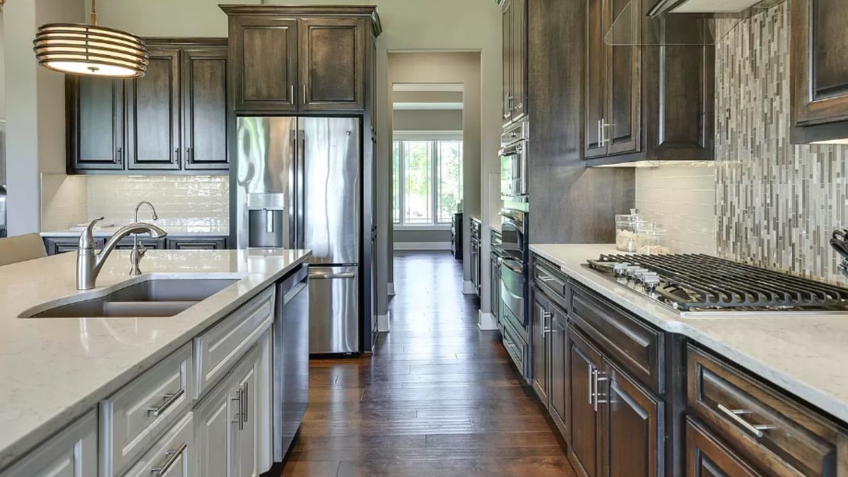 A kitchen with countertops, sink, cabinets, and kitchen appliances