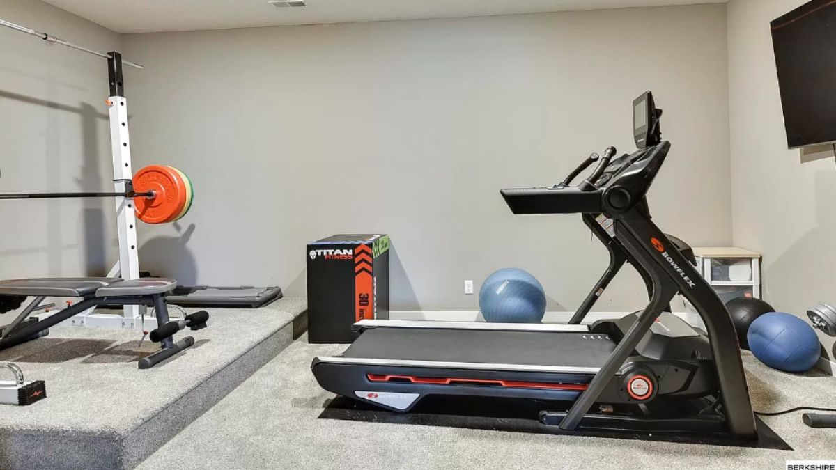 A home gym with a TV and gym equipment.