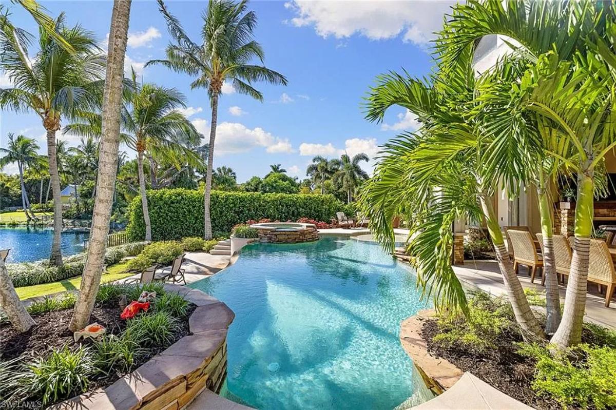 Pool with a jacuzzi and lounge chairs.