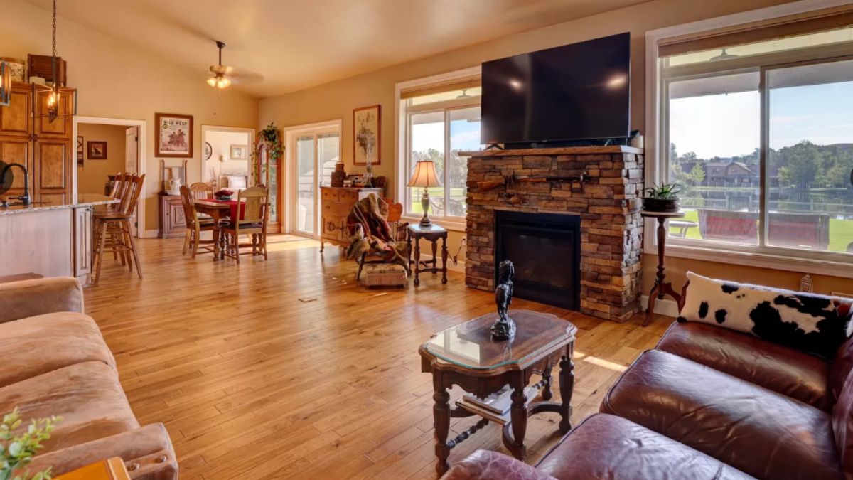 A living room with windows, a TV, fireplace, couches, chairs, and a coffee table.