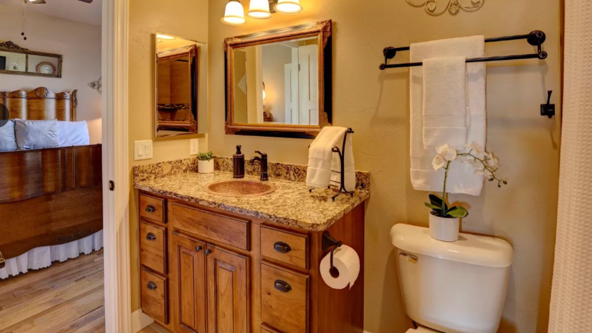 A bathroom with a vanity, cabinet, mirror, and toilet.