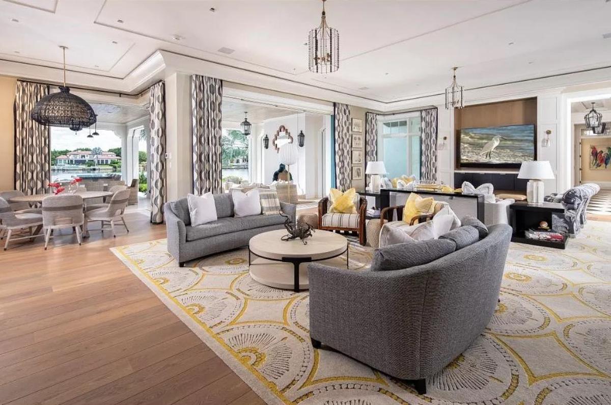 Living room with couches, tables and hardwood flooring.