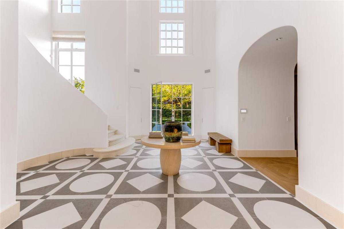 Foyer with a wood table and tile flooring.