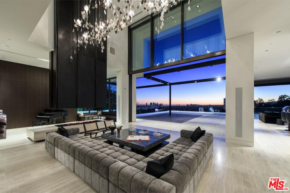 Living room with couches, a fireplace and chandeliers.