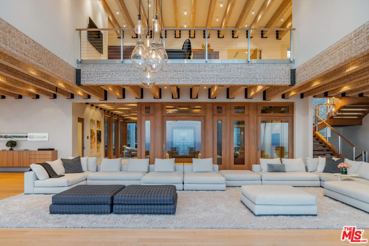 Living room with couches and hardwood flooring.