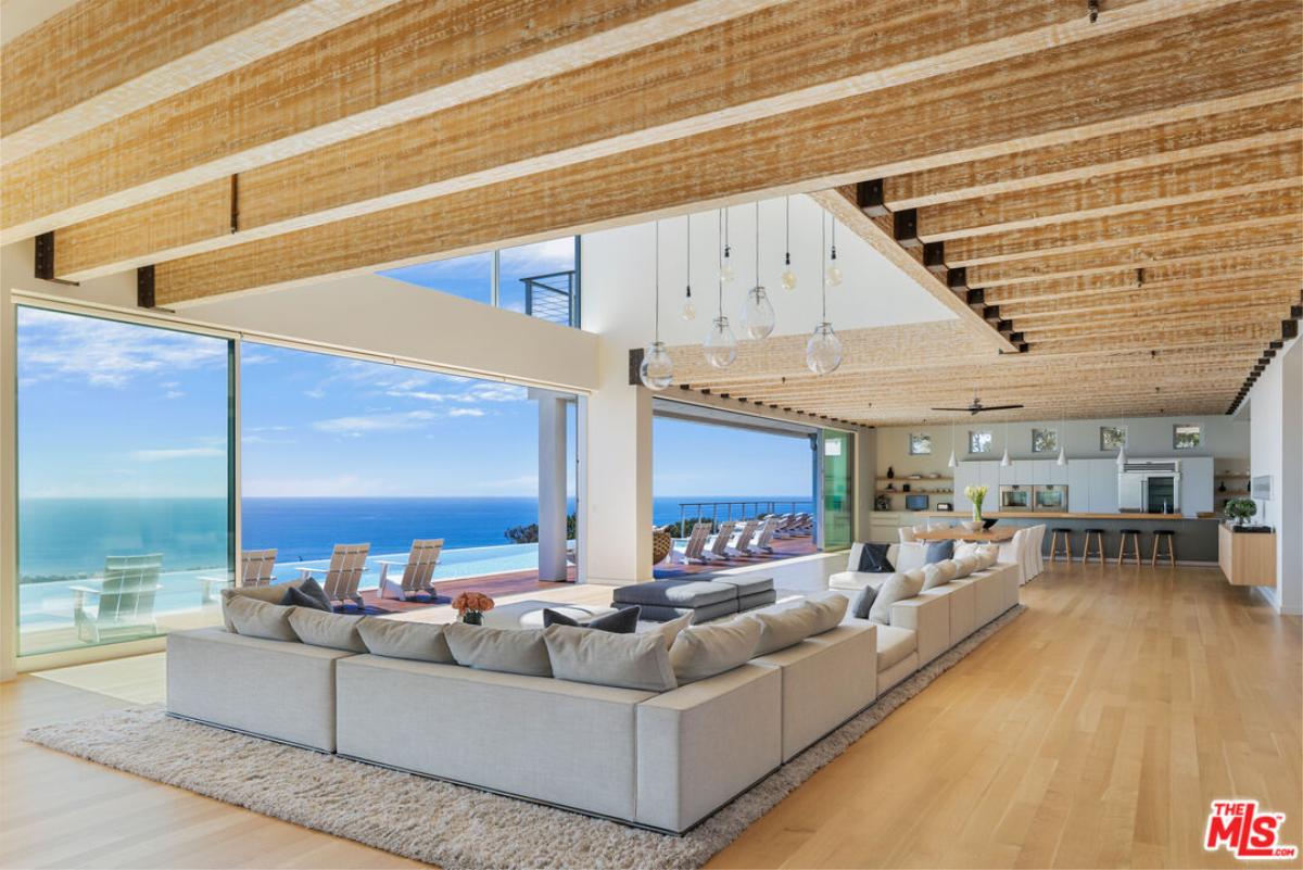 Living room with couches and hardwood flooring.