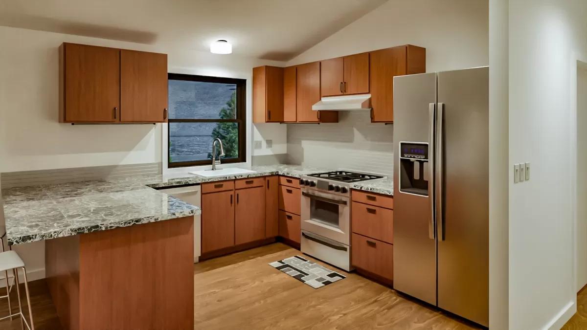 Kitchen with wooden cabinets, granite counters, and stainless steel appliances.