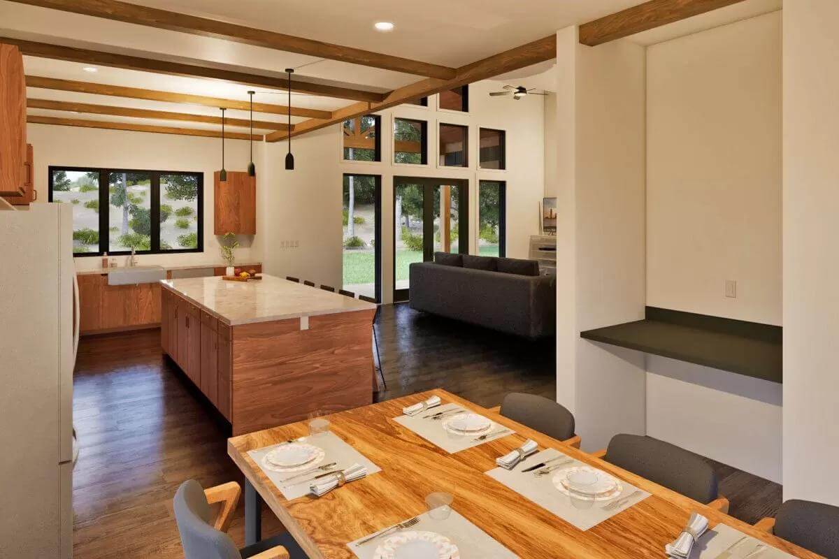 Dining area and kitchen crowned by a beamed ceiling.