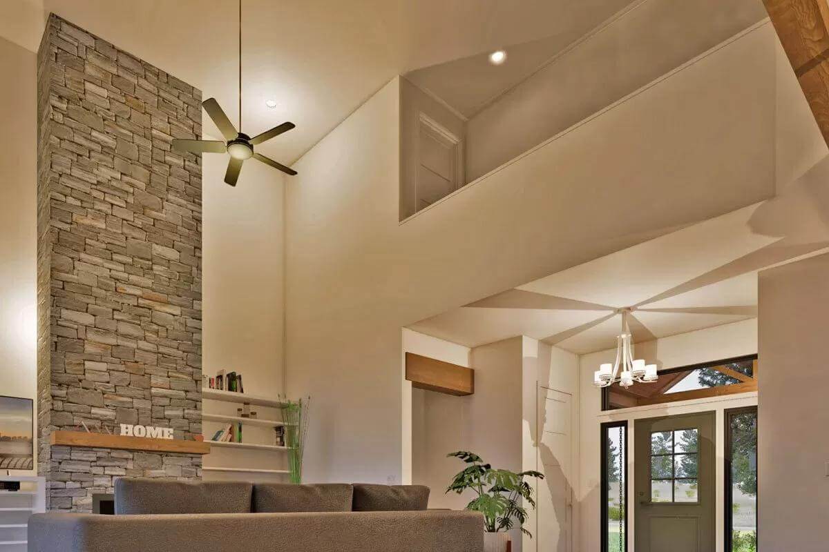 Living room with a sectional sofa and a stone fireplace under a tall ceiling.