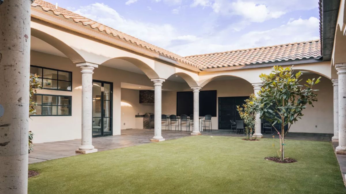 A courtyard with grass and trees.