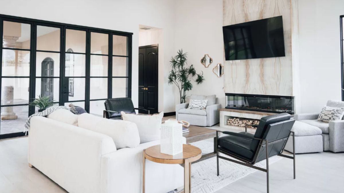 A living room with a TV, fireplace, couches, chairs, and a center table.