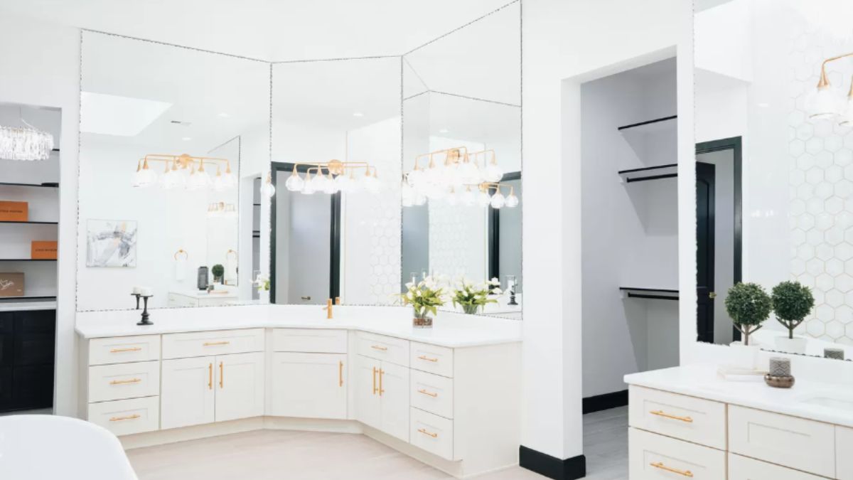 A bathroom with countertops, sink, mirrors, and cabinets.