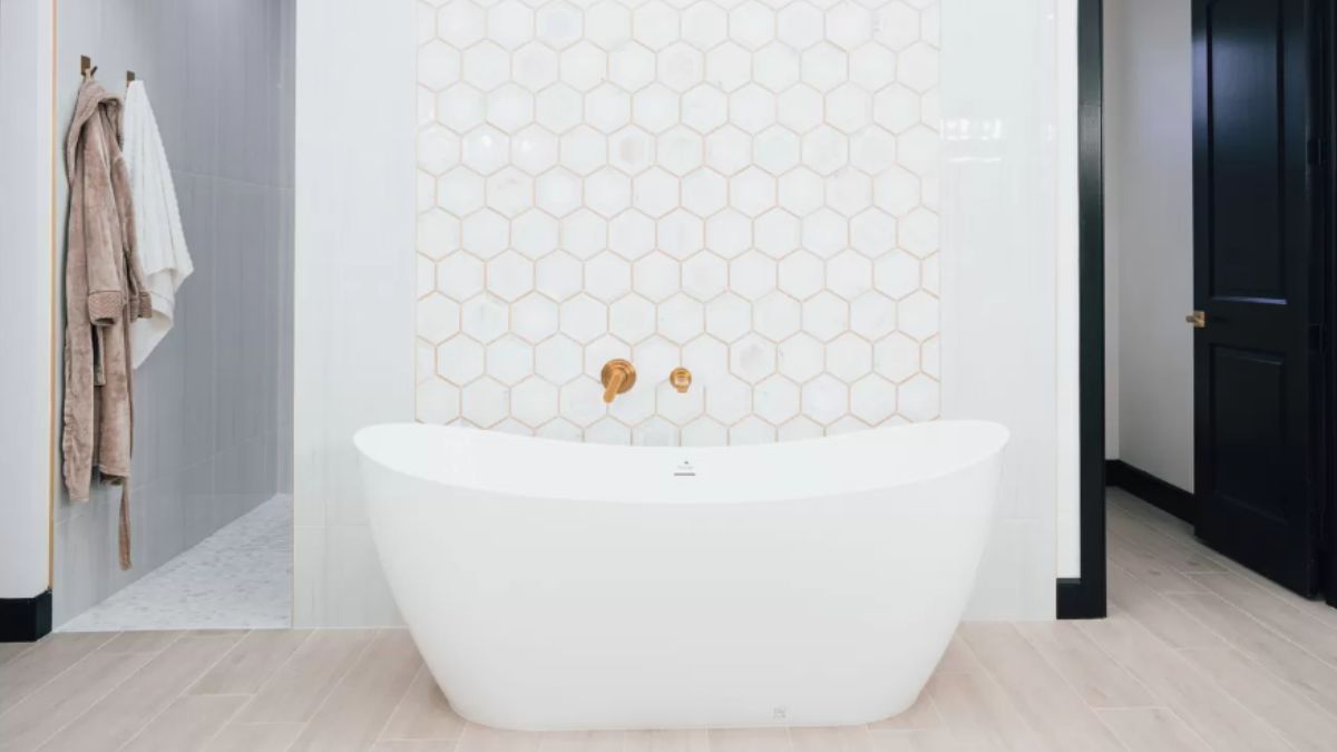 A bathroom with tiled walls and a bathtub.