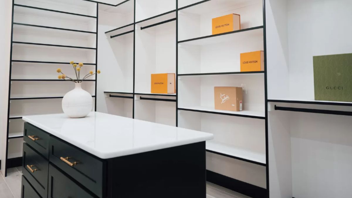 A walk-in closet with shelves, a center island, and drawers.