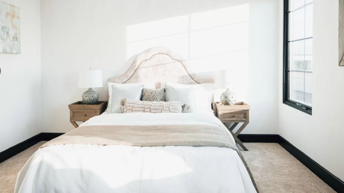 A bedroom with a bed, window, and nightstands.