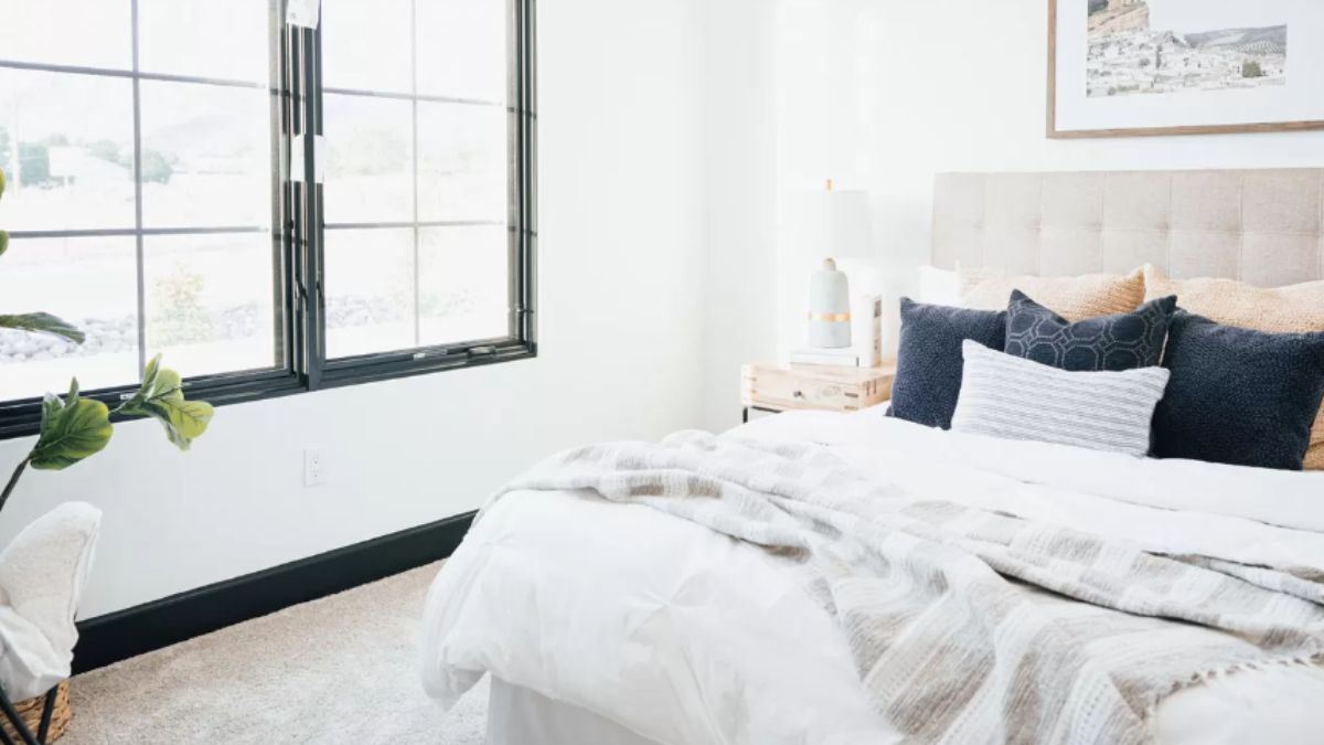 A bedroom with a bed featuring a headboard and a window.